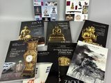 several books on a table with a clock on top of it