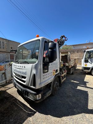 un camion blanc avec une grue à l'arrière