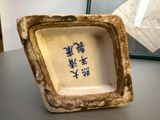 a small bowl with writing on it sitting on a table