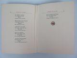 an open book with a poem on it on a blue surface