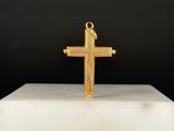 un gros plan d'une croix en or posée sur un socle blanc