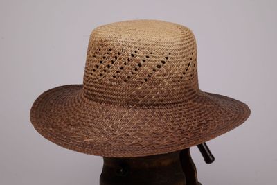 un chapeau marron troué, posé sur la tête d'un mannequin