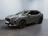 Une voiture grise est garée dans une pièce aux murs blancs.