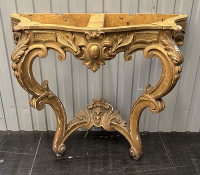 une console dorée avec un plateau en bois et des sculptures ouvragées