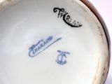 a close up of a white cup with blue writing on it