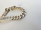 un gros plan sur un bracelet en argent sur lequel est gravé un prénom