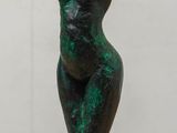 a statue of a woman sitting on top of a wooden table