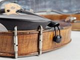a close up of a violin case with a guitar in the background