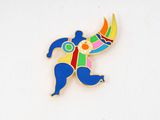 a colorful pin with a man holding a tennis racquet