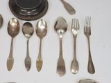 a lot of silver spoons, forks and spoons on the table