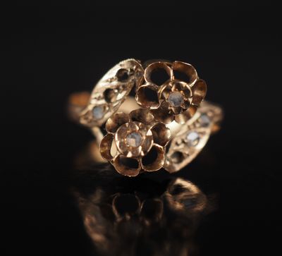 gros plan d'une bague en or sur une surface noire