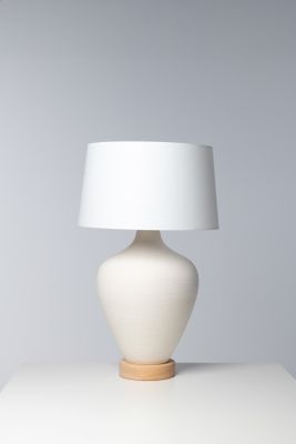 une lampe de table blanche surmontée d'un abat-jour blanc