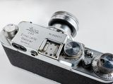 a silver camera sitting on top of a white table