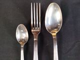 three spoons and a fork on a black table