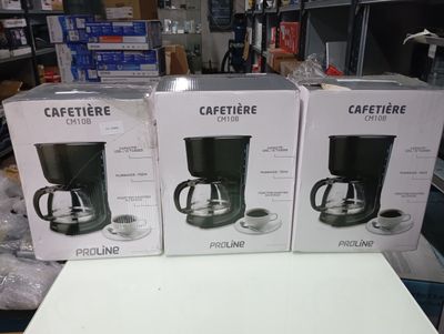 three boxes of coffee makers sitting on a table in a store