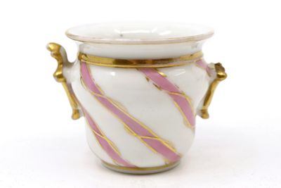 a white and pink vase with gold handles on a white surface