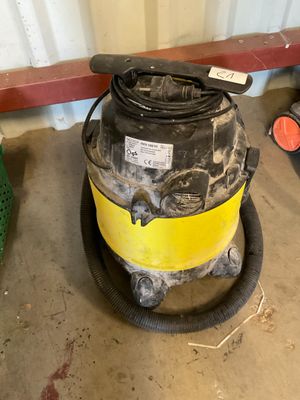 a yellow and black vacuum sitting on the floor next to other items