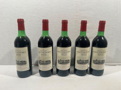 quatre bouteilles de vin sont alignées sur une table