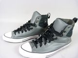 Des baskets Converse grises et noires avec des lacets noirs sur fond blanc