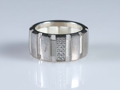 gros plan d'une bague avec des diamants sur une surface blanche