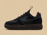 La Nike Air Force 1 Low est une chaussure en daim noir dotée d'une semelle marron