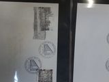two pieces of paper with stamps on them on a table