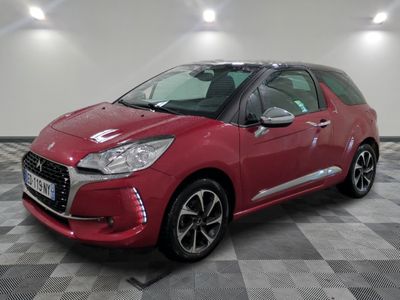 une citrole rouge garee sur un plancher en damier dans un garage