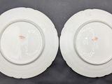 two white plates sitting on top of a table next to each other