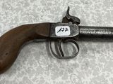 un vieux pistolet muni d'une étiquette, posé sur une table