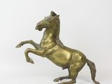 brass statue of a horse on its hind legs on a white background