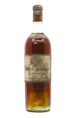 une vieille bouteille de whisky posée sur une surface blanche