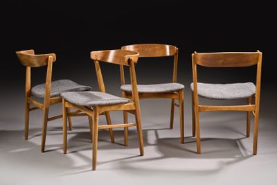 three wooden chairs with grey cushions sit in a dark room
