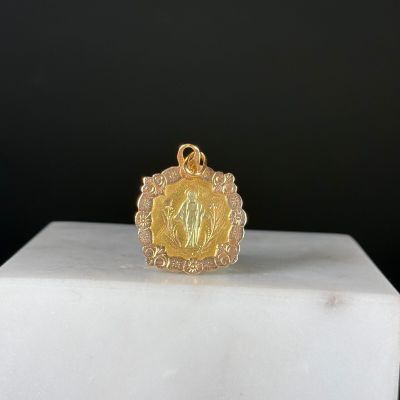 une image représentant un pendentif en or orné du portrait d'une femme