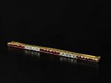 a gold and ruby bar brooch with diamonds