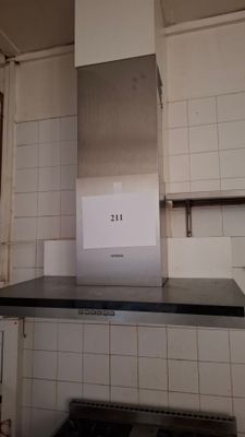 a picture of a stove in a kitchen with a sign on it