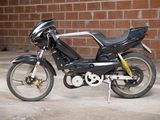 a black motorcycle parked in front of a brick wall