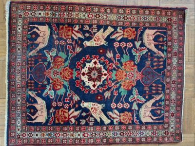 an image of a rug with animals and flowers on a wooden floor
