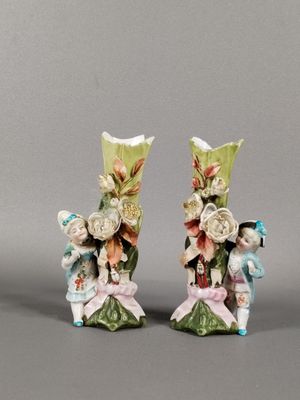 paire de figurines en porcelaine représentant deux personnes ornées de fleurs