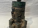 a statue of a bird sitting on top of a tree stump