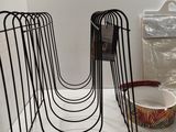 a black wire rack with a bowl and a bowl on it