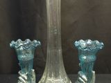 trois vases en verre posés l'un à côté de l'autre sur une table