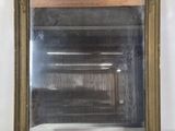 une image d'un miroir encadré d'or sur un mur blanc