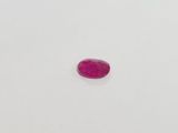 a pink oval shaped stone on a white surface