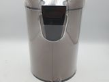 a silver trash can with a black lid on a white table