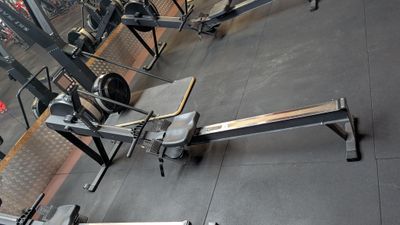 a picture of a gym room with a bench and weights