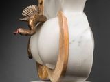 a white vase with a bird on top of it
