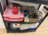 a shelf that has a lot of utensils and pans on it