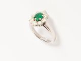 an emerald and diamond ring on a white background