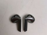 two black ear buds sitting on top of a white table