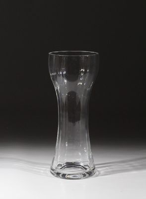 un vase en verre posé sur une table, sur fond noir